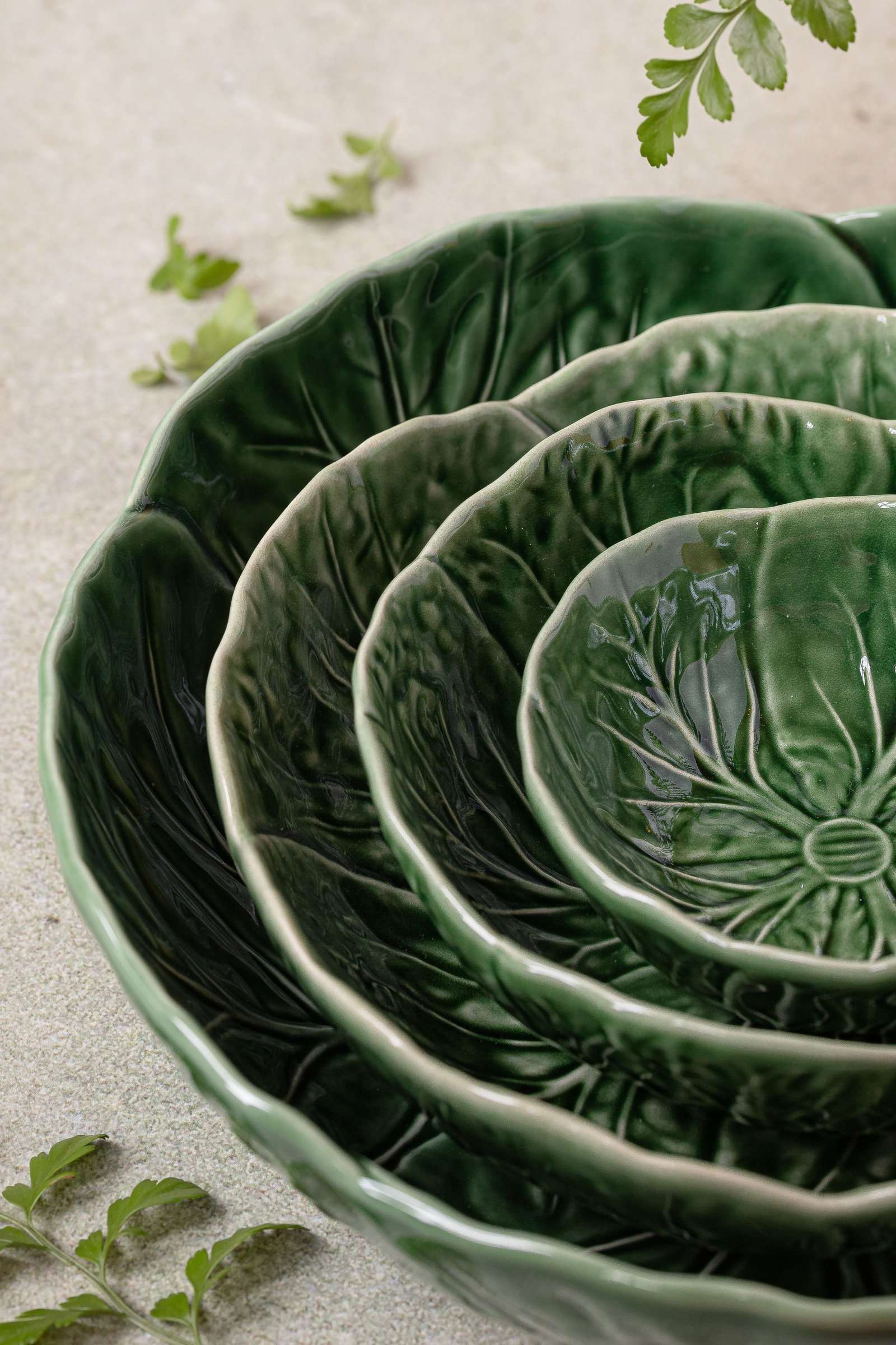 Green ceramic bowls with a sprig of fern