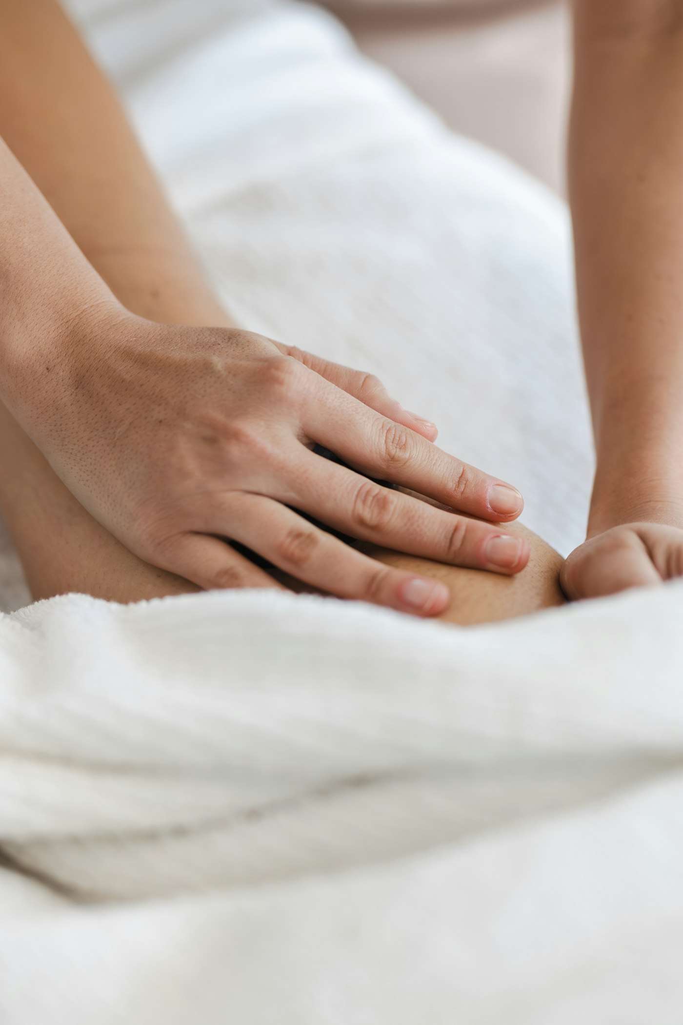 Handen die een been masseren boven een handdoek